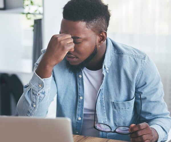 man at computer feeling fatigued