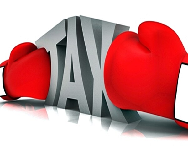boxing gloves squeezing the tax word