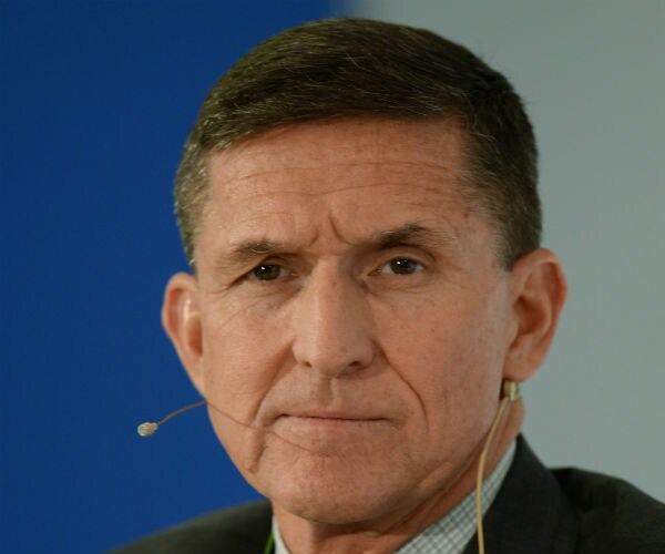 flynn looks toward camera with earpiece in his ear