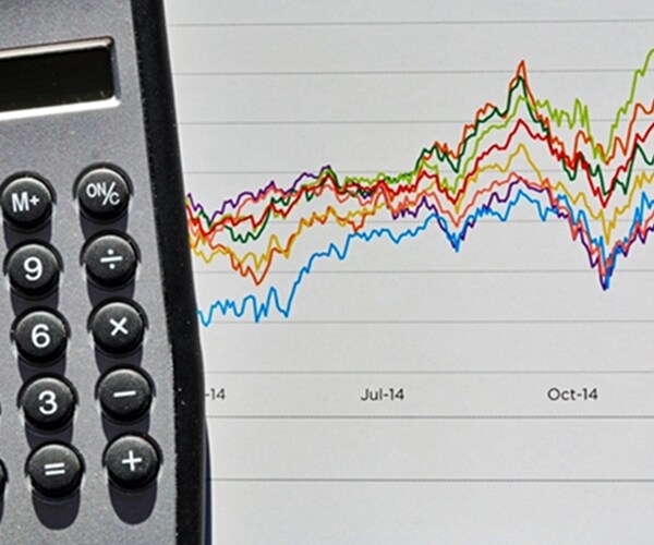 calculator next to bar graph of stock market volatility