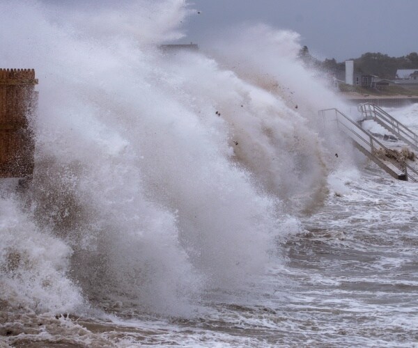 Waves pound a seawall.