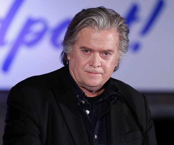 steve bannon stands behind podium