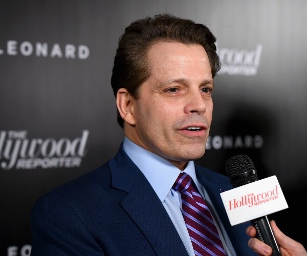 scaramucci in a navy blue suit lighter blue shirt and purple striped tie speaking into a mic