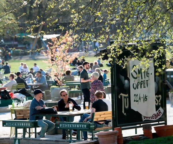 people sit outside in the warm weather in sweden 