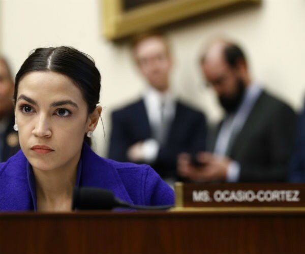 rep. alexandria ocasio-cortez seats and stares down someone during a house hearing