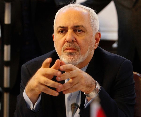 a man clasps the fingers of both hands together