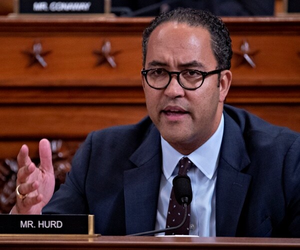 hurd in a navy blue suit and light blue shirt with polka dotted tie