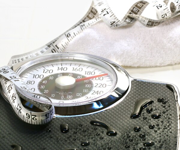 a scale, tape measure, and towel siting on a floor