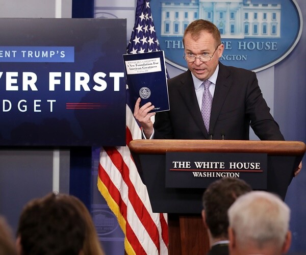 mick mulvaney holds up a copy of the federal budget when he was director of omb