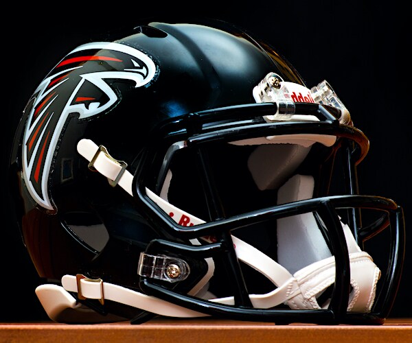 the black atlanta falcons helmets rests on a brown table