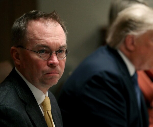 mulvaney in a dark gray suit and yellow tie sitting next to trump