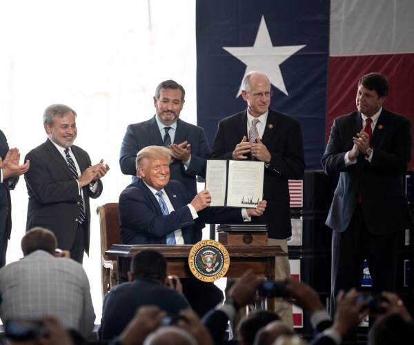 donald trump holds up a paper in texas