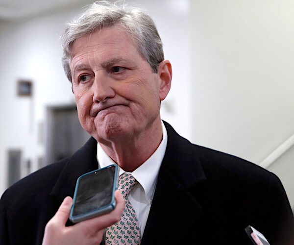 john kennedy speaks into a reporter's smart phone during an interview