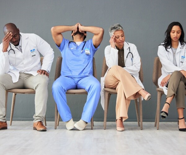 doctors, nurses, healthcare workers sitting in chairs looking tired