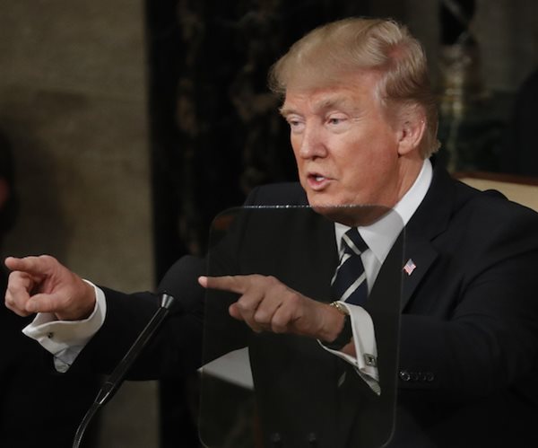 president donald trump points to the crowd with both index fingers straight out in front of him