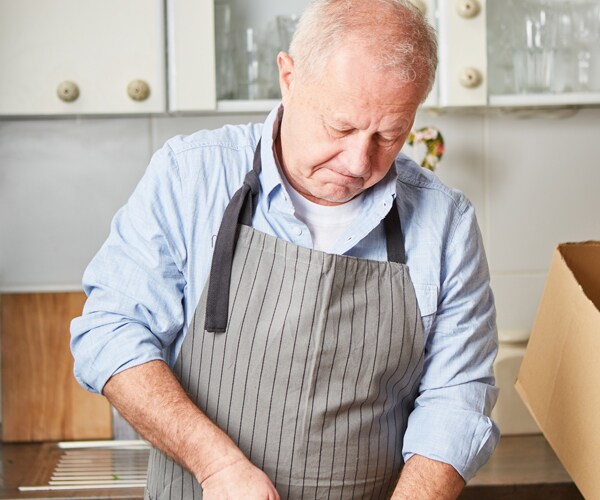 an older man cutting vegetables in the kitchen
