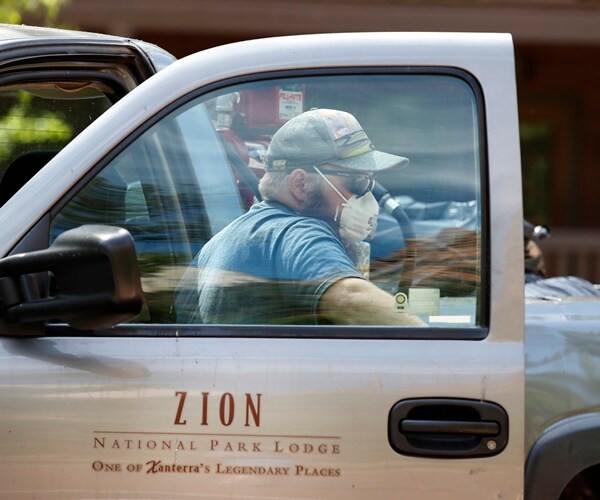 a masked maintenance man gets out of his truck in zion national park