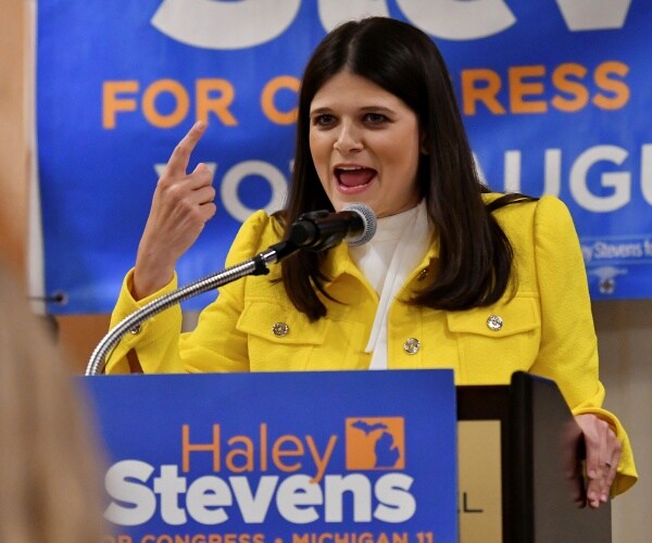 haley stevens speaks into a microphone