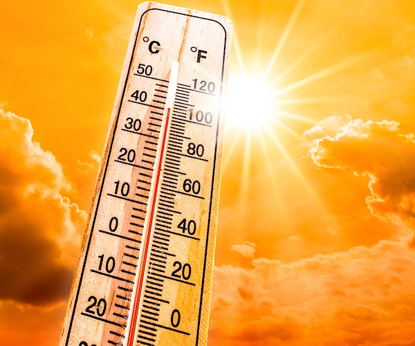 A heat wave concept showing a glowing yellow sky and a thermometer.