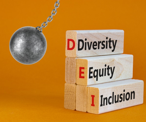 a wrecking ball knocking down blocks spelling out deversity equity and inclusion