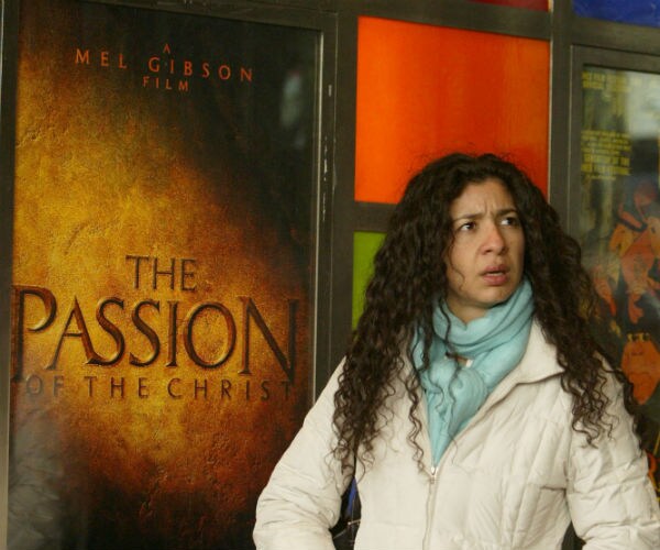 a young person is shown carrying 'the passion of the christ' sign