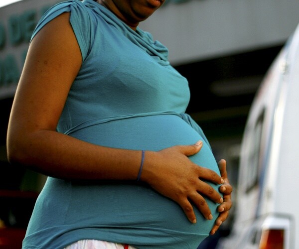 pregnant woman holds belly