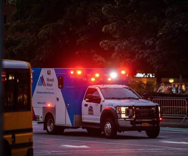 An ambulance with lights on going to an emergency