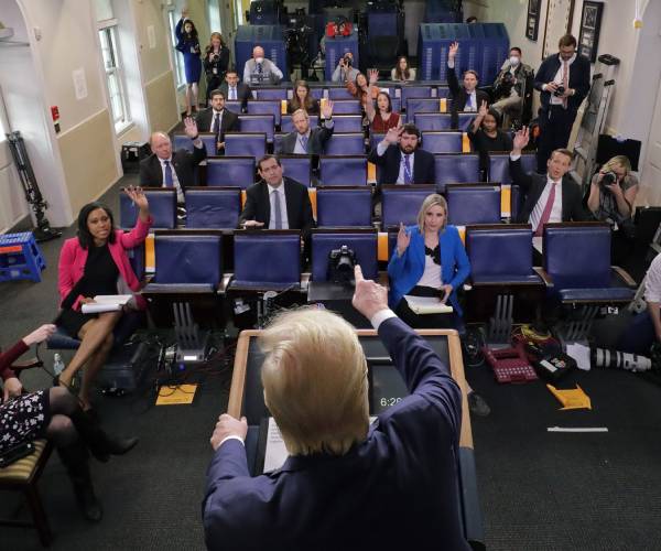 president trump seen from behind addressing reporters at the while house briefing room