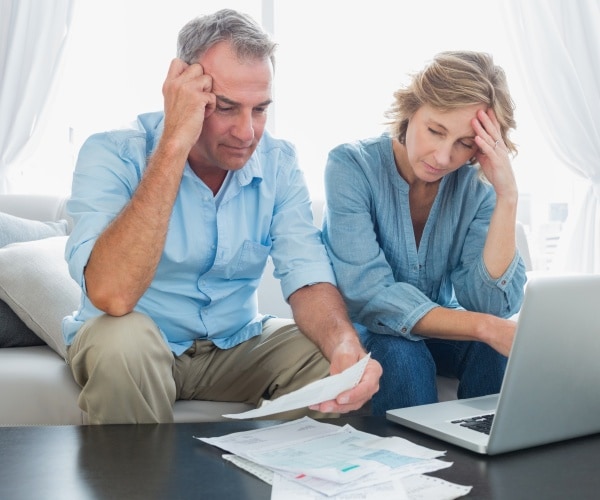 older man and woman looking stressed over bills