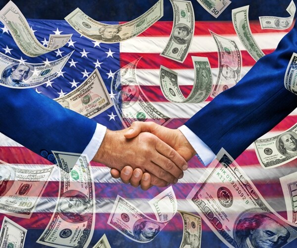 pair of businessmen shaking hands with an american flag and money falling down around them 

