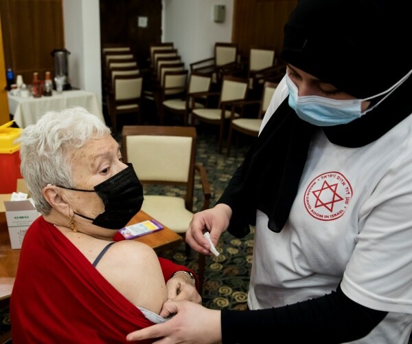 A senior citizen receives a fourth dose of the coronavirus vaccine