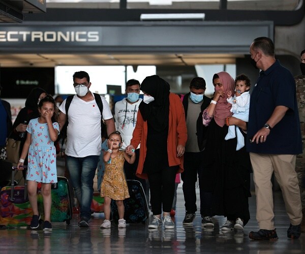 afghan refugees walk through airport