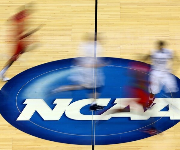 players on the basketball court play over a ncaa logo