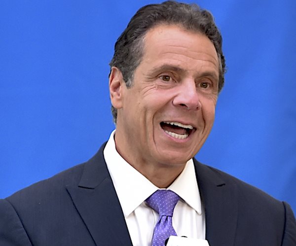 andrew cuomo smiles during a news conference when he was the new york governor