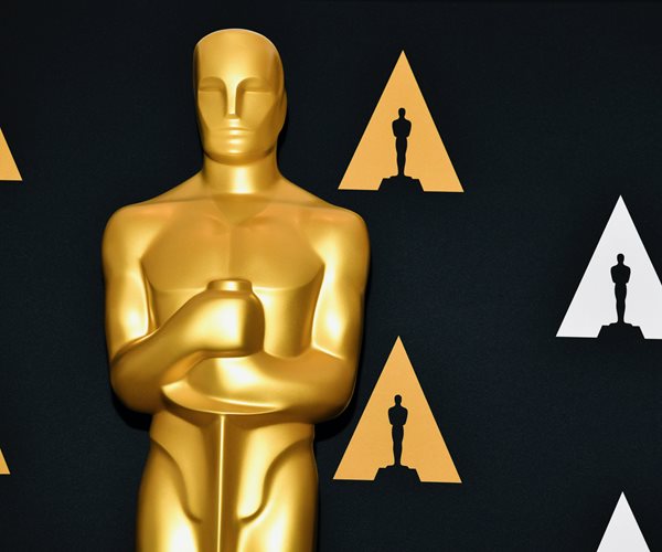 closeup of a golden oscar statuette against a dark background