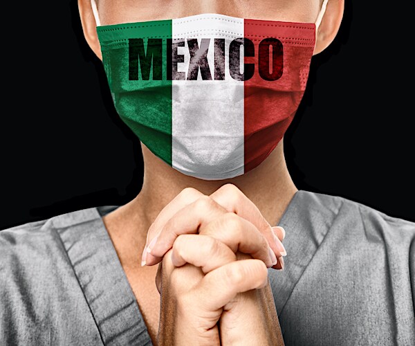 a nurse prays wearing a face mask with the mexico flag and mexico on it