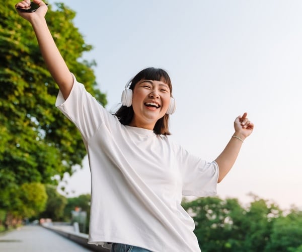 young woman smiling while wearing headphones