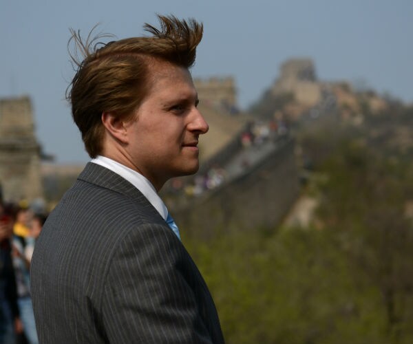 Christopher Nixon Cox stands at the great wall of china