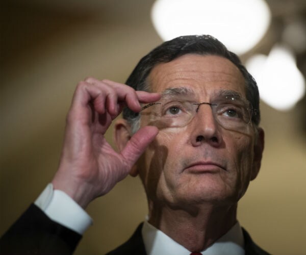 sen. john barrasso is shown adjusting his eyeglasses