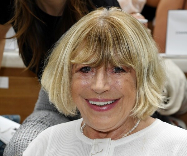 faithfull in a white top and pearl necklace