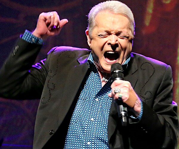 Late country music legend and "Urban Cowboy" star Mickey Gilley exults on stage during a performance