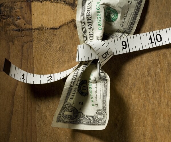 horizontal image of a US dollar tied with a measuring tape 