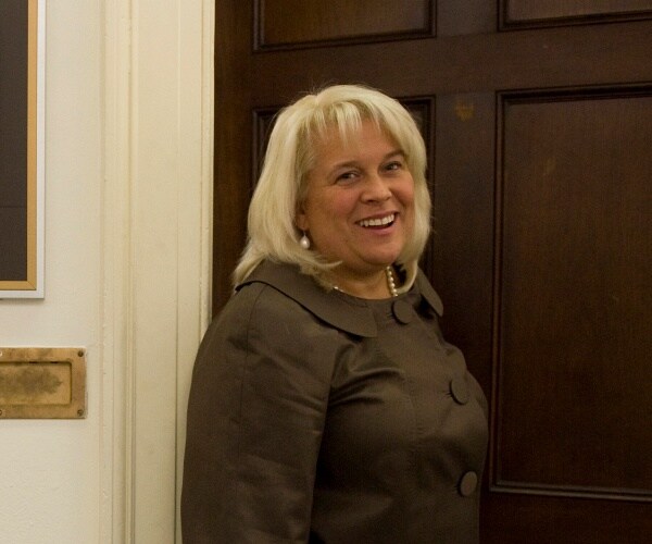 jennifer van der heide stands in front of office door
