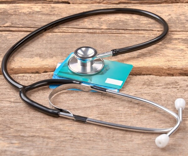 a stethoscope 'listening' to a credit card