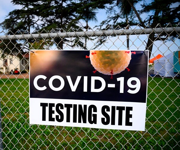 a testing site sign hangs in a minority community