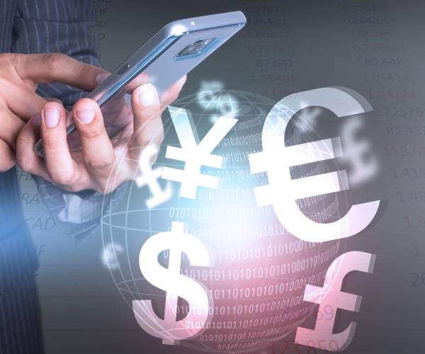 a man using a cellphone with different world currencies represented