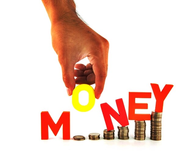 hand pick up o alphabet from money wording, standing on coins stack

