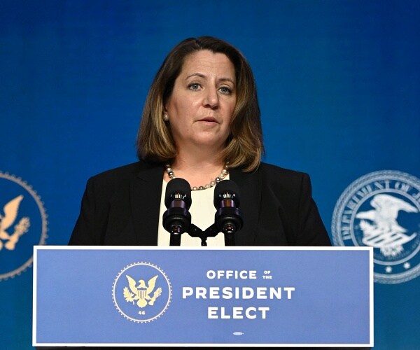 lisa monaco stands behind podium