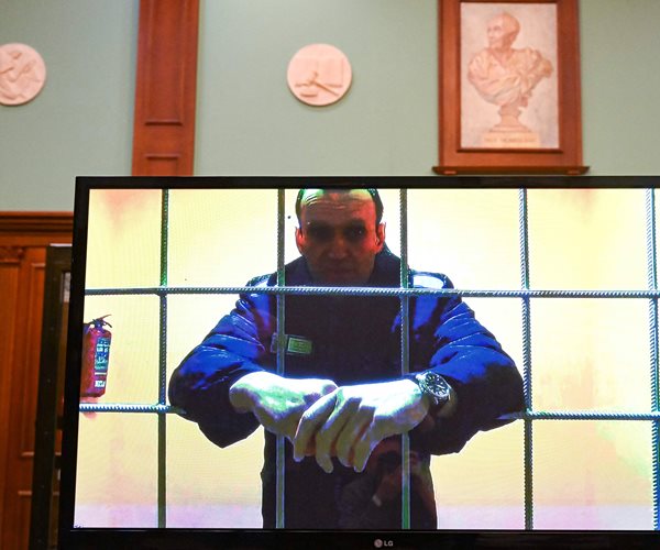 alexei navalny on a tv screen in a courtroom