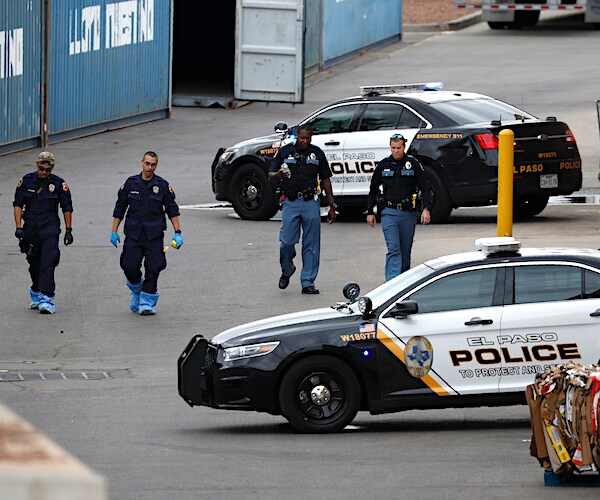 Police officers walk behind a Walmart at the scene of a mass shooting at a shopping complex in El Paso, Texas